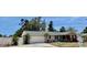 Exterior elevation of house with updated garage door, fence and landscaping at 14530 Apache Ave, Largo, FL 33774
