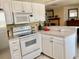 Efficient kitchen featuring white appliances, laminate countertops, and ample storage space at 14530 Apache Ave, Largo, FL 33774