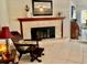 Living room featuring a fireplace, a comfortable chair and neutral-colored tile flooring at 14530 Apache Ave, Largo, FL 33774