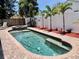 Backyard pool with pavers, a jacuzzi and surrounded by palm trees and a white fence at 14530 Apache Ave, Largo, FL 33774
