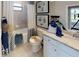 Bright bathroom features a shower and tub combination with grey tiling, a framed mirror, and white cabinets at 15021 Oxford Grey Dr, Lakewood Ranch, FL 34211