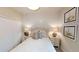 Bright bedroom showcasing modern white shiplap wall with matching nightstands and decorative wall art at 15021 Oxford Grey Dr, Lakewood Ranch, FL 34211