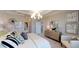 Tastefully decorated bedroom features stylish wall art, a contemporary chandelier, and a comfortable seating area at 15021 Oxford Grey Dr, Lakewood Ranch, FL 34211