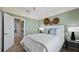 Comfortable bedroom with muted green walls, soft carpet, a ceiling fan, and a peek into another room at 15107 Oxford Grey Dr, Bradenton, FL 34211