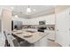 Bright kitchen boasts white cabinets, granite countertops, stainless steel appliances, and breakfast bar seating at 15107 Oxford Grey Dr, Bradenton, FL 34211