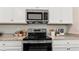 Kitchen highlights stainless steel oven, granite countertops, and white cabinets with ample storage at 15107 Oxford Grey Dr, Bradenton, FL 34211