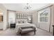 A serene bedroom showcases a decorative accent wall, plush carpet and a stylish chandelier at 15107 Oxford Grey Dr, Bradenton, FL 34211