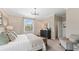 Sunlit bedroom featuring a dresser, a sitting chair, and large windows with natural light streaming in at 15127 Oxford Grey Dr, Bradenton, FL 34211