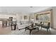Inviting living area with a comfortable sofa, accent chairs, sliding glass doors to the backyard, and a kitchen in background at 15127 Oxford Grey Dr, Bradenton, FL 34211
