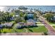 Stunning aerial view of coastal homes with manicured lawns and views of the bay in the distance at 1794 Santa Barbara Dr, Dunedin, FL 34698
