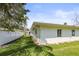 Well-maintained backyard featuring a white fence, lush lawn, and mature trees at 1794 Santa Barbara Dr, Dunedin, FL 34698