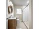 Well-lit bathroom featuring wood vanity, and white tiled shower at 1794 Santa Barbara Dr, Dunedin, FL 34698