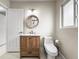 Bright bathroom featuring a modern wood vanity, round mirror, and toilet at 1794 Santa Barbara Dr, Dunedin, FL 34698
