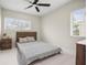 Cozy bedroom with natural light from two windows, neutral walls, and wood-look tile flooring at 1794 Santa Barbara Dr, Dunedin, FL 34698