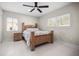 Spacious bedroom with a wooden bed frame, ceiling fan, and plenty of natural light from two windows at 1794 Santa Barbara Dr, Dunedin, FL 34698