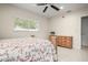 Bedroom with neutral walls, a wooden dresser, and bright natural light from the window at 1794 Santa Barbara Dr, Dunedin, FL 34698