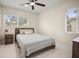 Bedroom featuring a dark wood bed frame, neutral decor, and bright natural light from the windows at 1794 Santa Barbara Dr, Dunedin, FL 34698