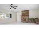 Living area showcasing brick fireplace, sleek ceiling fan, and natural light from the large window at 1794 Santa Barbara Dr, Dunedin, FL 34698