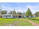 Charming single-story home with a brick pathway and bright blue shutters at 1794 Santa Barbara Dr, Dunedin, FL 34698