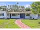 Beautiful home with brick path, blue shutters, and a lush green lawn at 1794 Santa Barbara Dr, Dunedin, FL 34698
