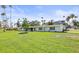 Charming single-story home with a well-manicured lawn and palm trees at 1794 Santa Barbara Dr, Dunedin, FL 34698