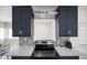 Stylish kitchen featuring stainless steel range hood, electric cooktop, and decorative tile backsplash at 1794 Santa Barbara Dr, Dunedin, FL 34698