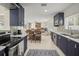 Stylish kitchen boasting stainless steel appliances, blue cabinets and an open layout to living room at 1794 Santa Barbara Dr, Dunedin, FL 34698