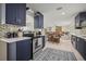 Modern kitchen featuring blue cabinetry, stainless steel appliances, and open layout to the living area at 1794 Santa Barbara Dr, Dunedin, FL 34698