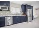Modern kitchen with stainless steel appliances, dark blue cabinets, and stylish backsplash at 1794 Santa Barbara Dr, Dunedin, FL 34698