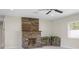 Cozy living room featuring a stone fireplace and natural lighting at 1794 Santa Barbara Dr, Dunedin, FL 34698