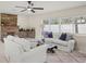 Comfortable living room featuring stone fireplace, natural light, and an open layout at 1794 Santa Barbara Dr, Dunedin, FL 34698