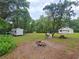 Expansive backyard with a fire pit, camper, and rustic seating, perfect for outdoor gatherings at 18452 Fort Dade Ave, Brooksville, FL 34601