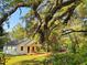 Quaint home with a welcoming front porch, framed by lush trees, offering a tranquil and private setting at 18452 Fort Dade Ave, Brooksville, FL 34601