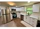Modern kitchen with stainless steel appliances, white cabinets, and granite countertops at 18452 Fort Dade Ave, Brooksville, FL 34601