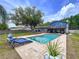 Inviting backyard with a sparkling pool, blue lounge chairs, and an expansive brick patio perfect for relaxing at 1902 Rebecca Rd, Lutz, FL 33548