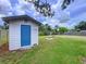 Backyard shed with a blue door offers extra storage space and enhances the property's functionality at 1902 Rebecca Rd, Lutz, FL 33548