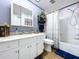 Bathroom with white fixtures, vanity with marble countertop, decorative mirror, and shower-tub combo at 1902 Rebecca Rd, Lutz, FL 33548