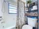 Bathroom showcasing a shower/tub with a floral shower curtain and a metal shelf for towels and accessories at 1902 Rebecca Rd, Lutz, FL 33548