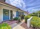Charming front entrance with a welcoming wreath, colorful flowers, and a clear view of the sky at 1902 Rebecca Rd, Lutz, FL 33548