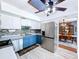 Stylish kitchen with white cabinets, blue lower cabinets, modern appliances, and an adjacent dining area at 1902 Rebecca Rd, Lutz, FL 33548