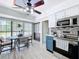 Bright eat-in kitchen boasts stainless steel appliances, a decorative ceiling fan, and large windows with backyard views at 1902 Rebecca Rd, Lutz, FL 33548