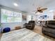 Living room featuring hardwood floors, a ceiling fan, comfortable seating, and natural light from a large window at 1902 Rebecca Rd, Lutz, FL 33548