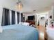 Spacious main bedroom featuring a chandelier, hardwood floors, a large window, and ensuite bathroom access at 1902 Rebecca Rd, Lutz, FL 33548