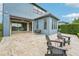 Charming back patio featuring travertine tiles, seating, and a lake view at 19191 Pease Pl, Lutz, FL 33558