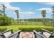 Relaxing backyard view with lake, iron fence, and chairs on the patio at 19191 Pease Pl, Lutz, FL 33558