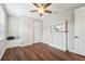 Neutral bedroom offering wood-look floors, ceiling fan, and built in bench and shelving at 19191 Pease Pl, Lutz, FL 33558