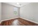 Empty bedroom featuring wood-look flooring, neutral walls, ceiling fan and window with blinds at 19191 Pease Pl, Lutz, FL 33558