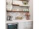 Stylish coffee bar featuring a wine fridge, open shelving, custom cabinetry, and unique brick backsplash at 19191 Pease Pl, Lutz, FL 33558