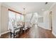 Bright dining room with hardwood floors, a chandelier, and access to staircase and living area at 19191 Pease Pl, Lutz, FL 33558