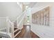 Bright entryway featuring wood floors, staircase, and an accent wall with a neutral-toned painting at 19191 Pease Pl, Lutz, FL 33558
